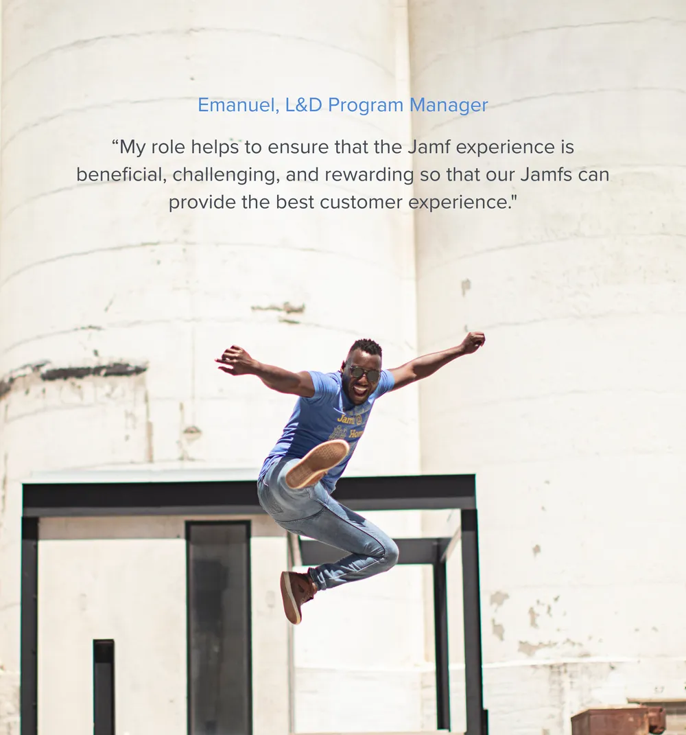A smiling Emanuel, L&D Program Manager, leaps joyfully in a blue
