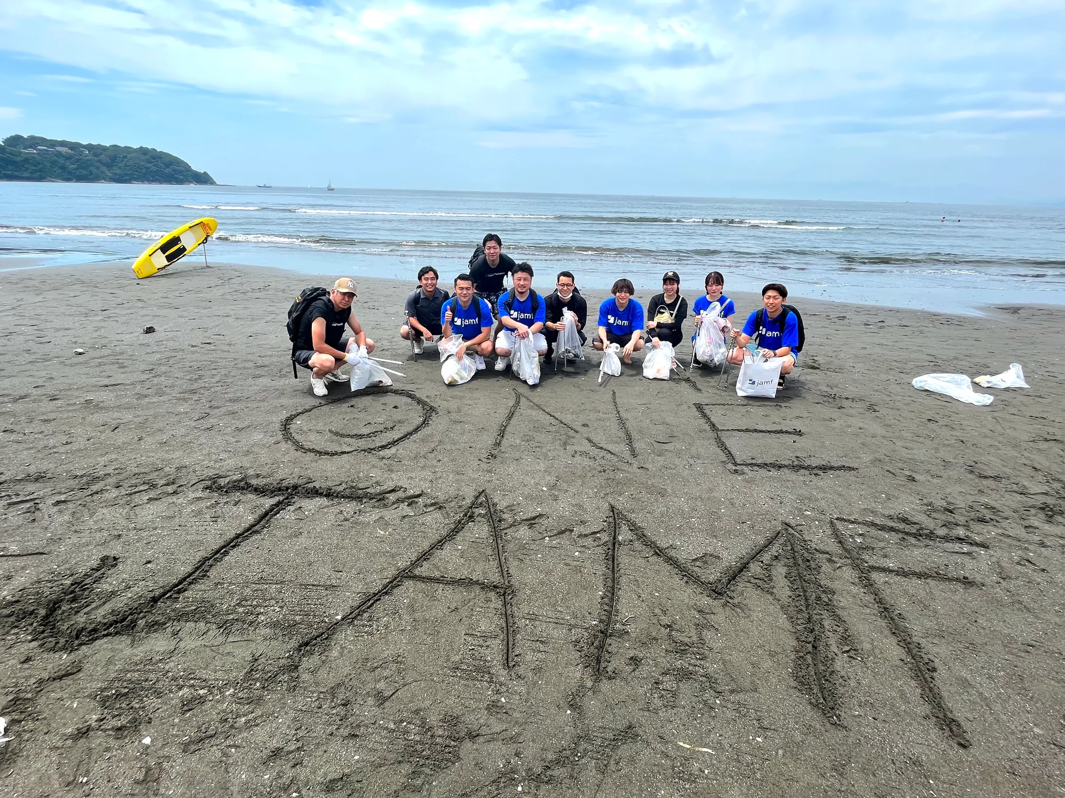 Group of people on a beach with Jamf spelled out in the sand