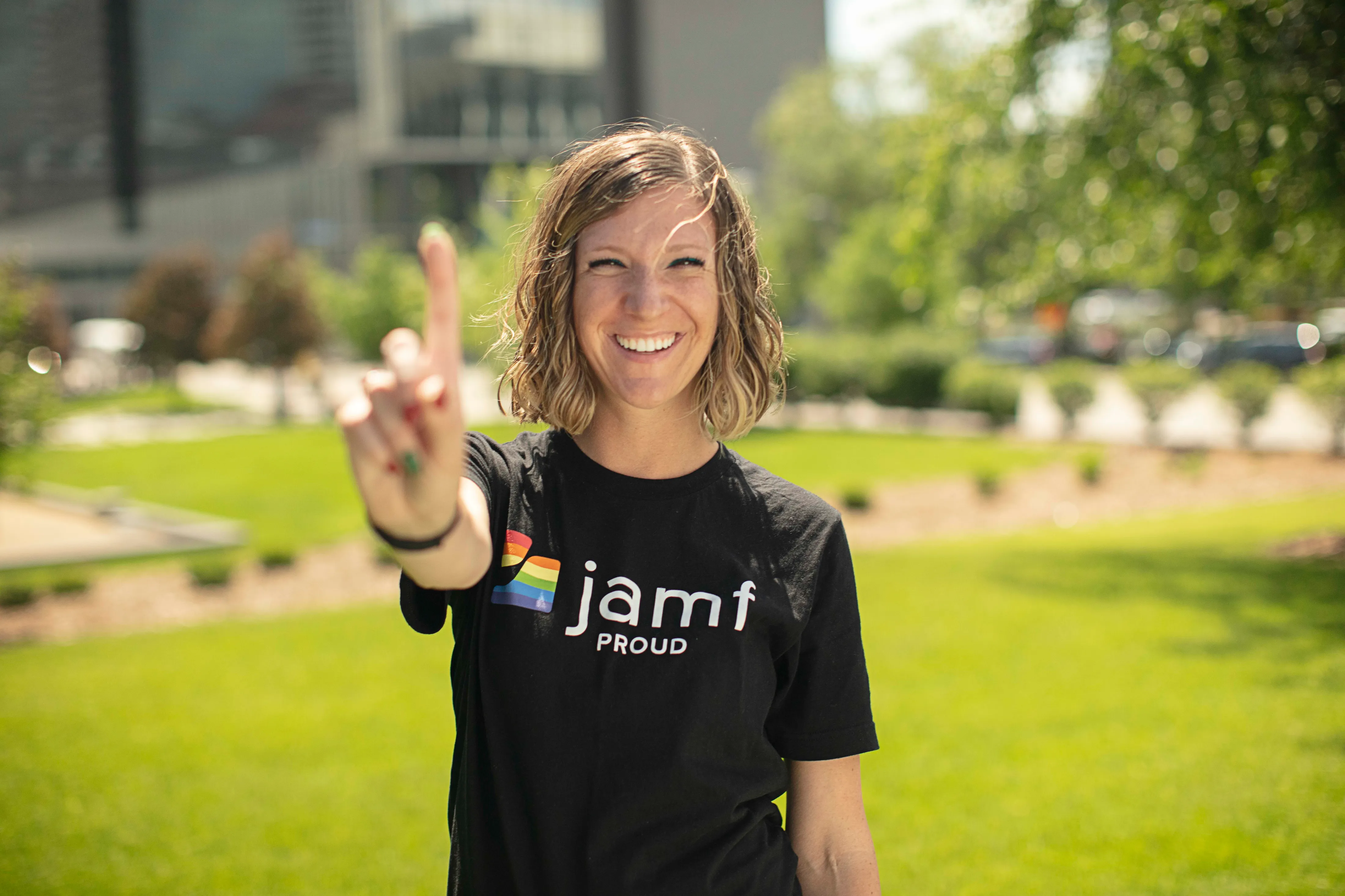 Person wearing Jamf shirt holding out hand to signal number 1