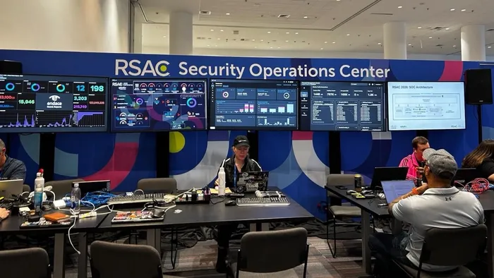 The RSAC security operations center with 5 large monitors showing network and activity dashboards as security professionals monitor