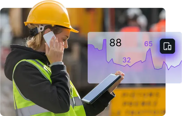 A construction worker in a yellow hard hat and safety vest uses a tablet displaying a purple graph with the numbers 88, 65, and 32. The interface suggests mobile device management, like Jamf, while the worker simultaneously talks on a smartphone.