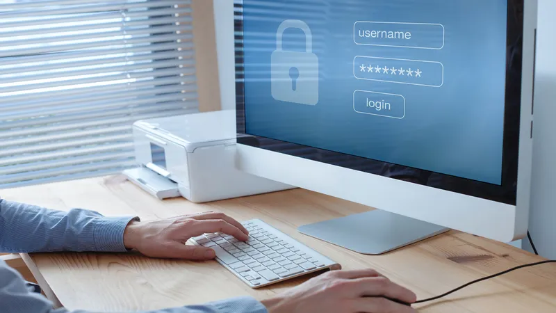 iMac on desk with user viewing a screen that is displaying a log in screen for password credentials
