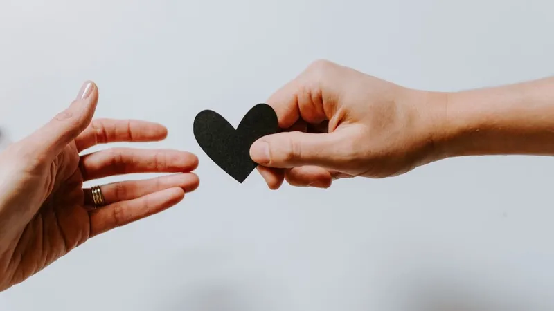 Person passing paper heart to another person