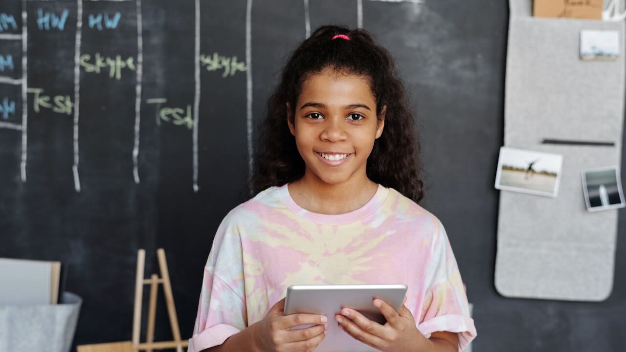 Young person in a classroom holding an iPad