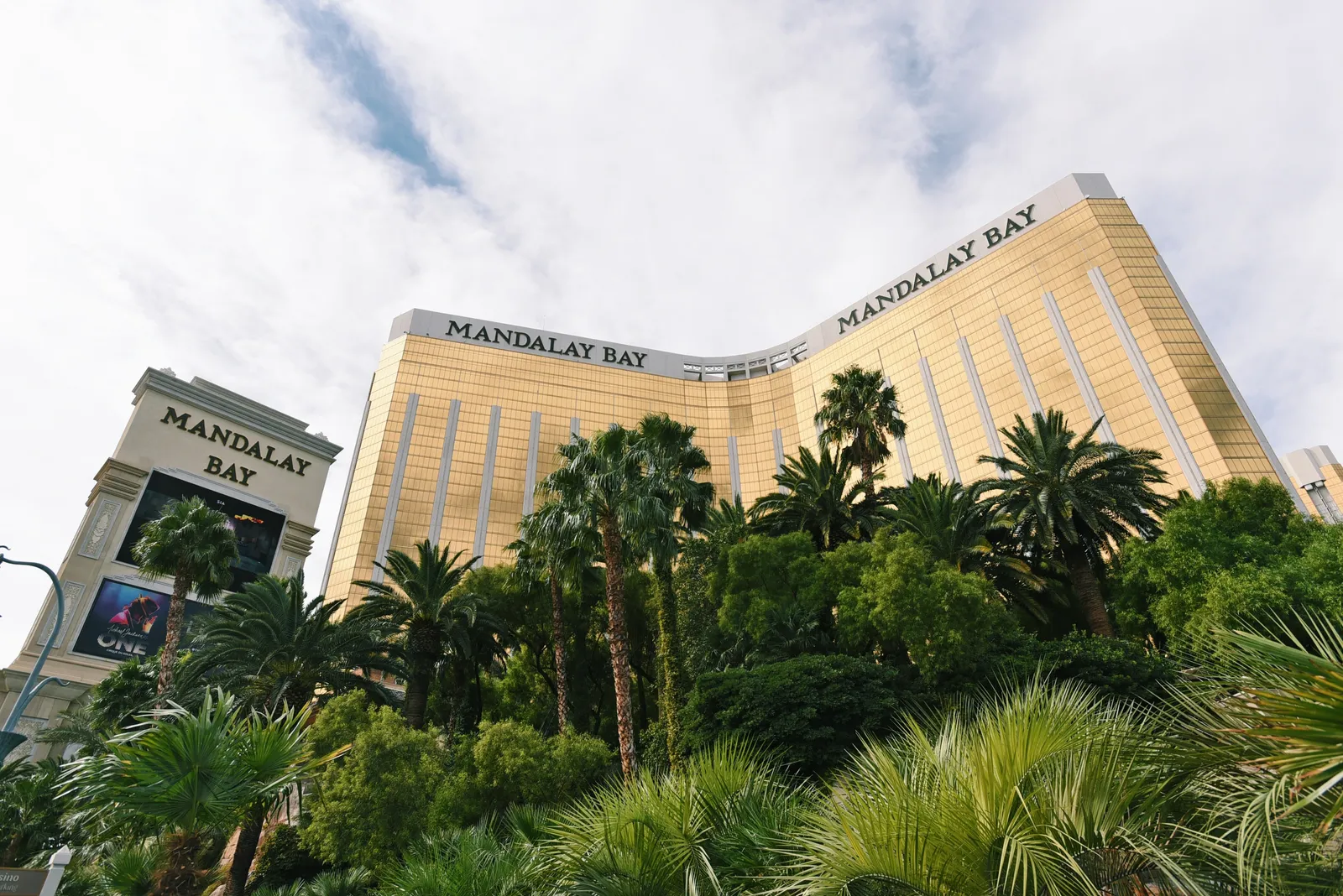 Exterior of Mandalay Bay Hotel in Las Vegas with trees in the foreground.