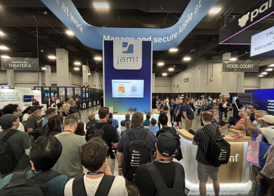 Crowd of attendees gathered at the Jamf booth at JNUC, featuring