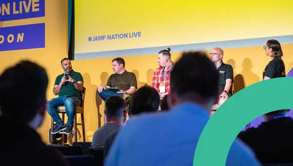 Four male panelists seated in a row on stage addressing the audience at Jamf Nation Live.