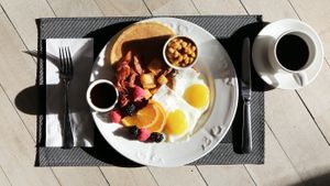 A tray on a wooden surface in bright sunlight, bearing a plate of breakfast foods and a cup of coffee