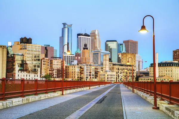 A pedestrian bridge leading toward the Minneapolis skyline.