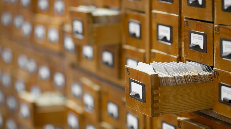 Card catalog open with cards organized when looking for specific books.