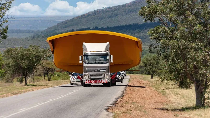 Semi-truck hauling oversized load on highway, preventing all other traffic.