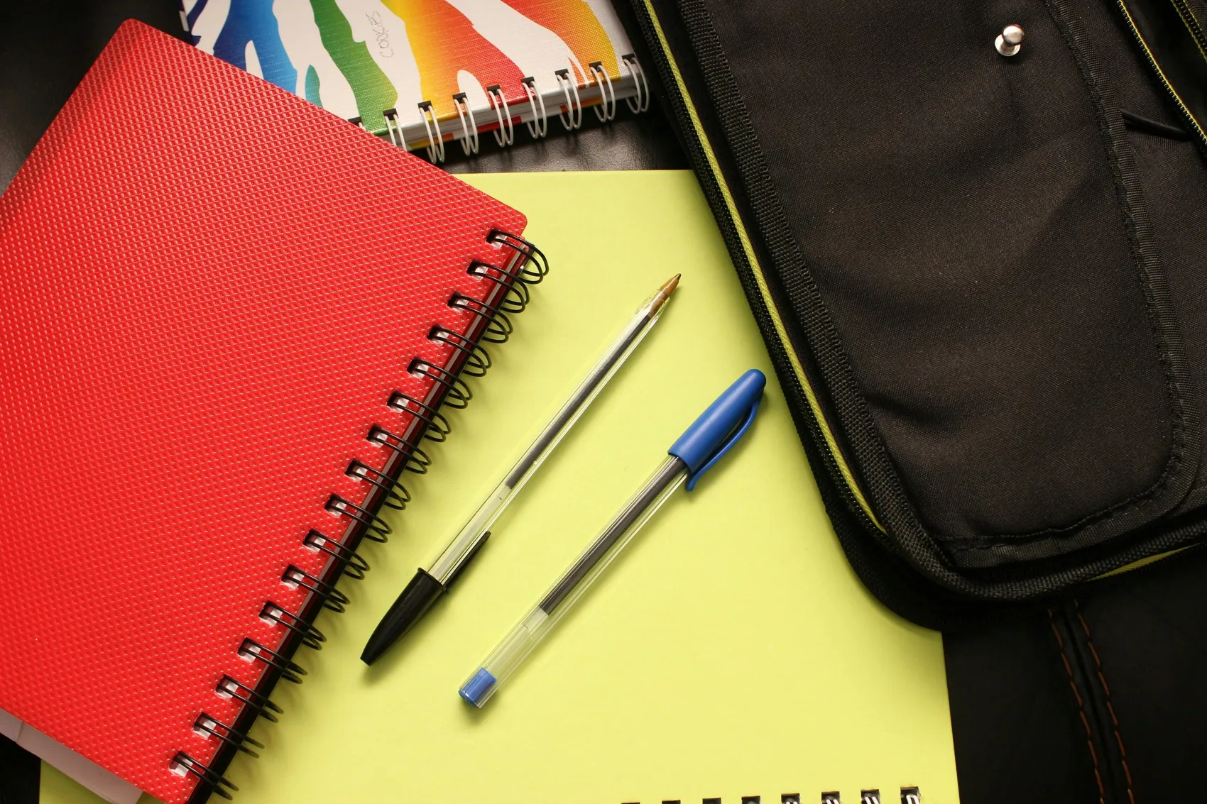 Stack of notebooks with two ballpoint pens