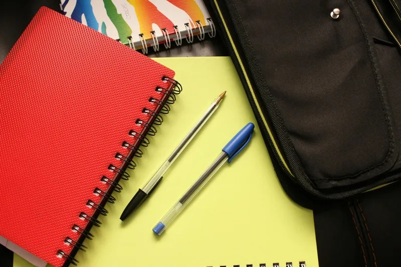 Stack of notebooks with two ballpoint pens