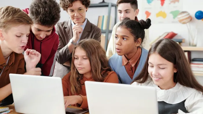 Group of students looking at Macbooks managed and secured by Jamf