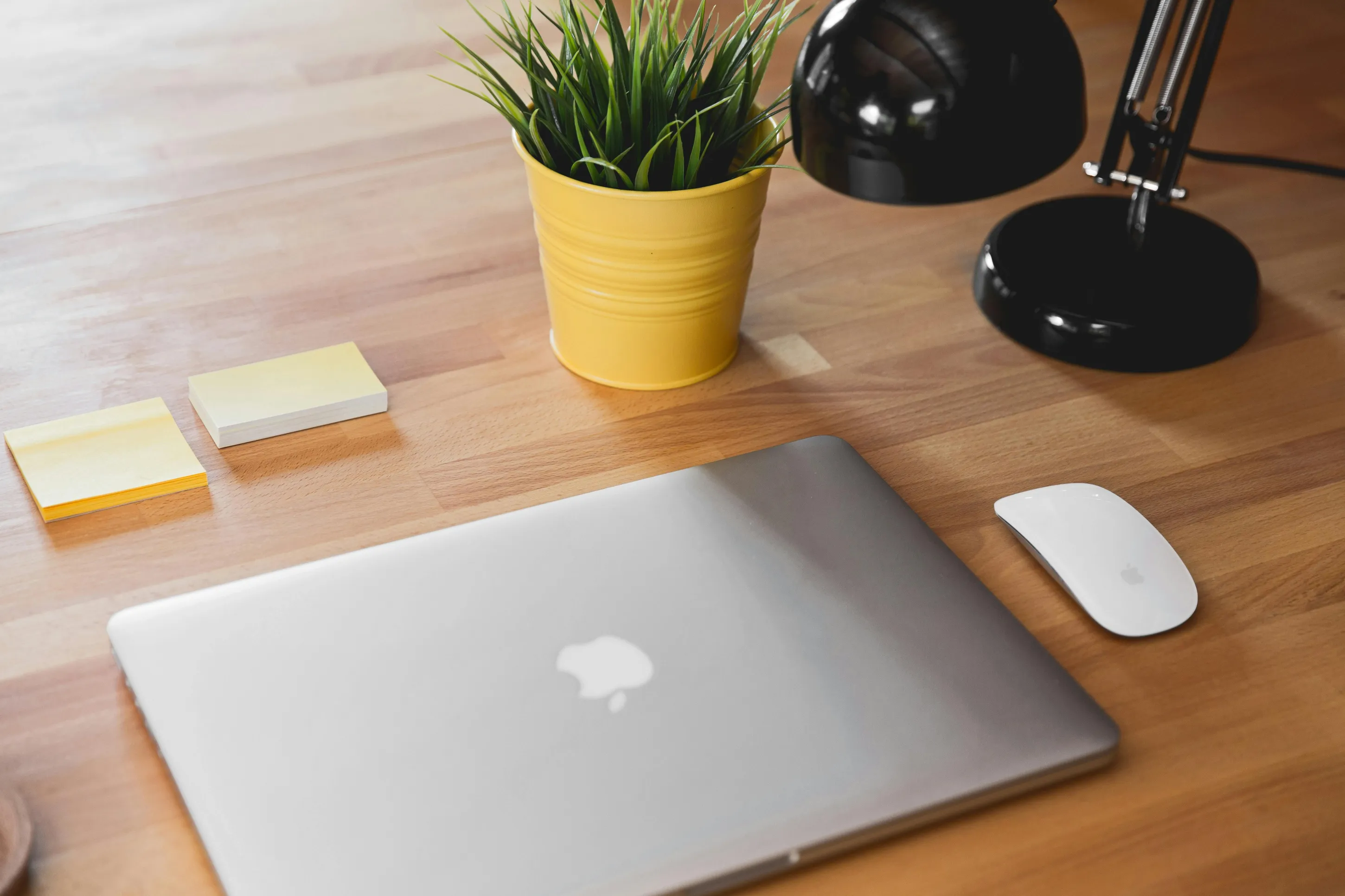 Closeup of a desk with MacBook managed and secured by Jamf.