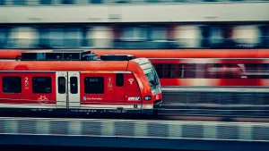Two red trains running on side-by-side tracks. The larger outpaces the smaller one, symbolizing how AI moves faster than enterprise security.