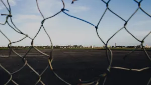 Missing links in a chain-link fence illustrate the holes in Enterprise security without AI governance.