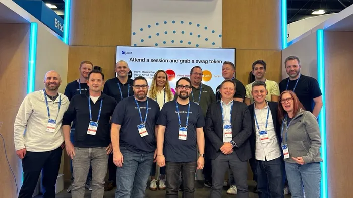 Group of Jamf employees posing for a photo in front of their RSAC booth