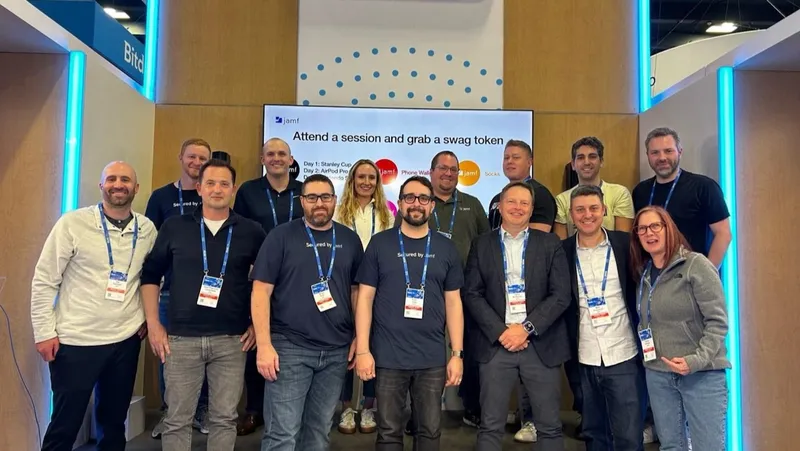 Group of Jamf employees posing for a photo in front of their RSAC booth