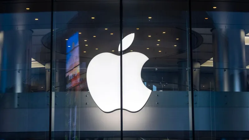 The outside of an Apple Store, focused on a glowing Apple logo