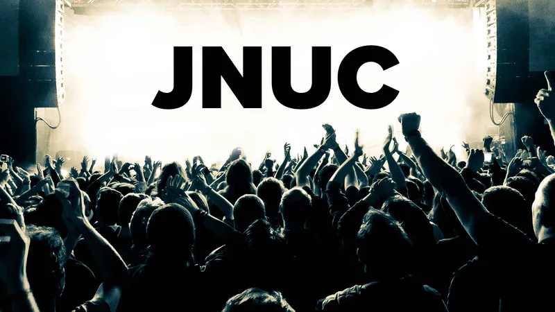 A crowd cheers in front of a JNUC sign