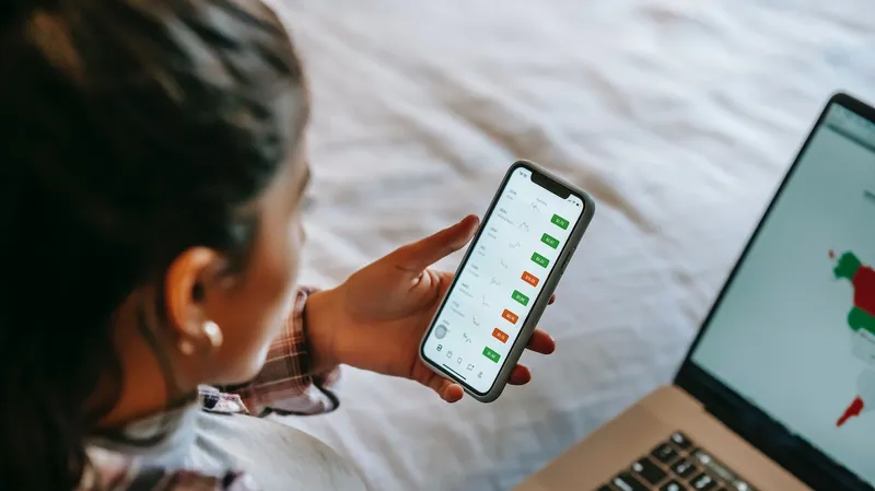 Woman looks at trading apps on mobile phone.
