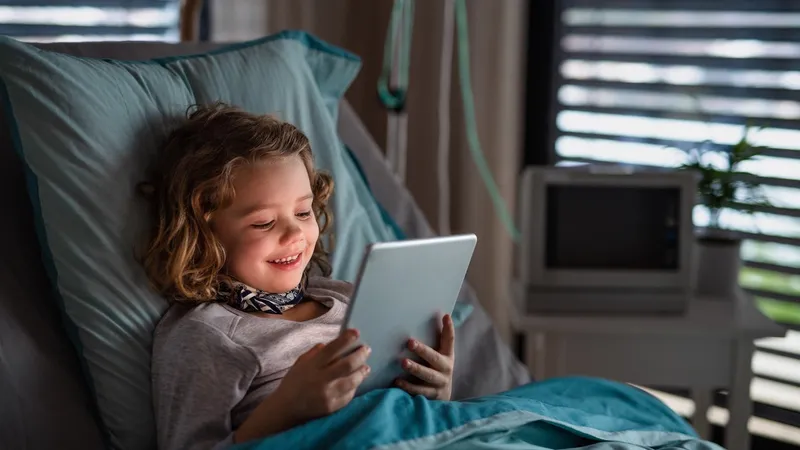 Girl in hospital bed looks at iPad managed by Jamf Pro.