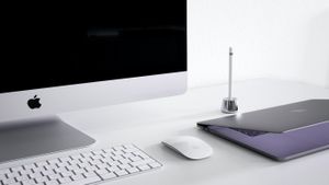 An iMac and MacBook sitting on a desk.