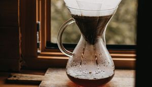 Coffee being filtered from beans into a glass cup
