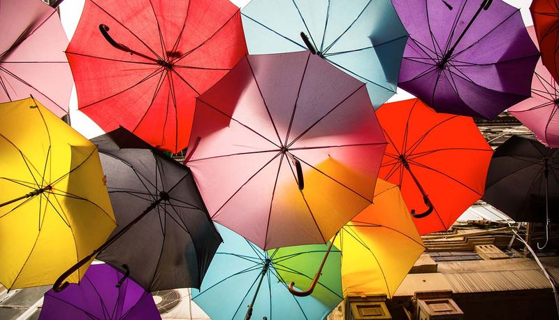 Multiple umbrellas of different colors overlapped to protect passerby's from getting wet
