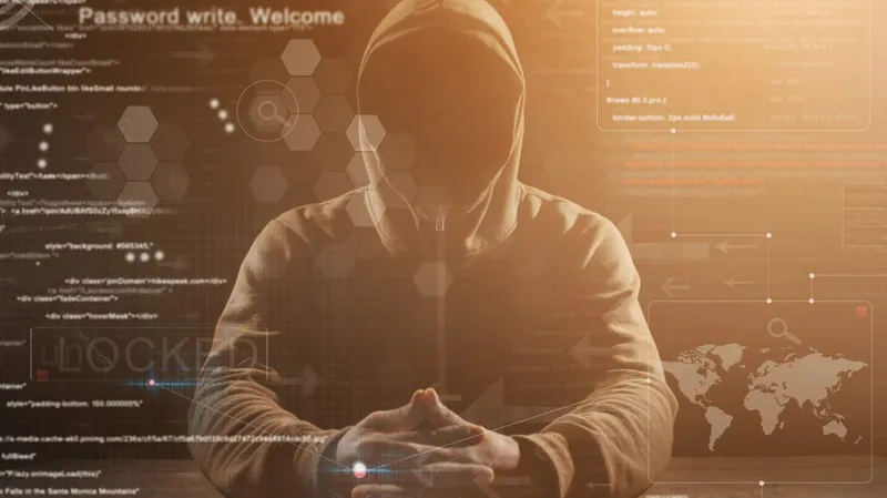 A hacker in a hoodie; code superimposed in front of him