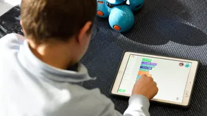 Young student using an iPad managed by Jamf School with apps obtained from the Apple Education Partner Program
