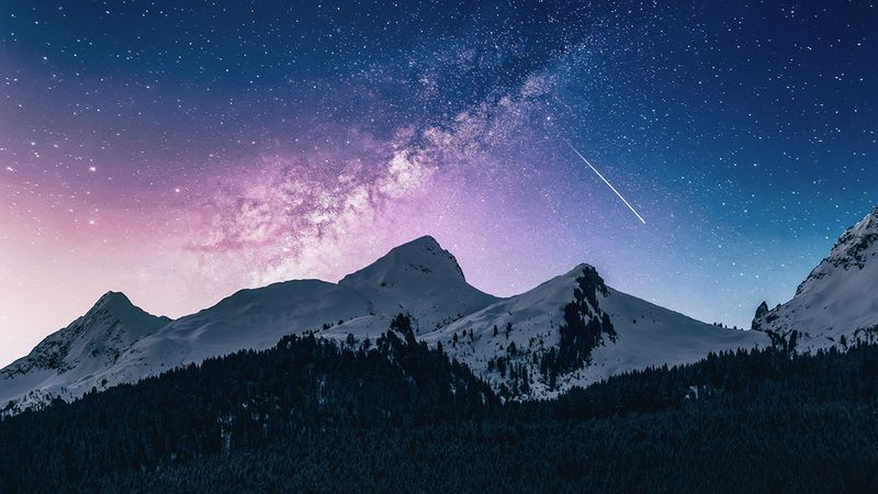 A falling star lights up a purple sky over mountains.