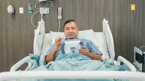 Patient using PillowCase iPad case with built-in nurse call button.