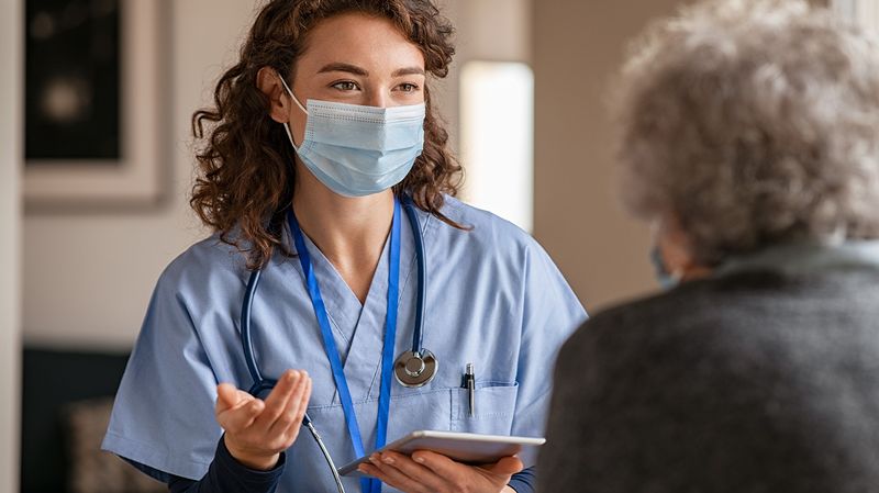 A nurse takes information from a patient using an iPad managed by Jamf Pro.