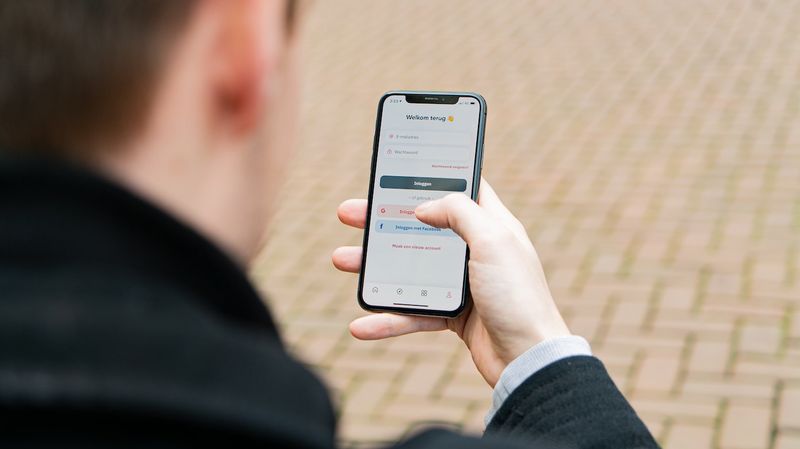 Man looks at mobile phone screen.