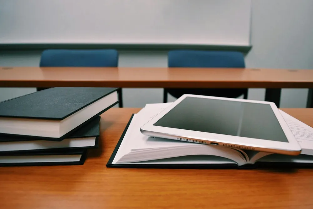 books and iPad sitting on top of a desk