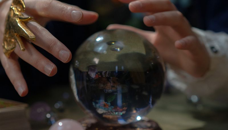 Crystal ball with hands conjuring up visions of the future