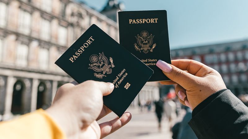 Two hands holding up passports