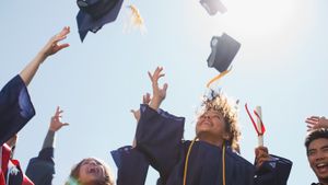Group of adults throwing graduation caps in air celebrating passing Jamf Certified Associates examination.