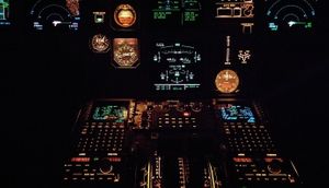 Airplane cockpit with all the meters and gauges lit up.