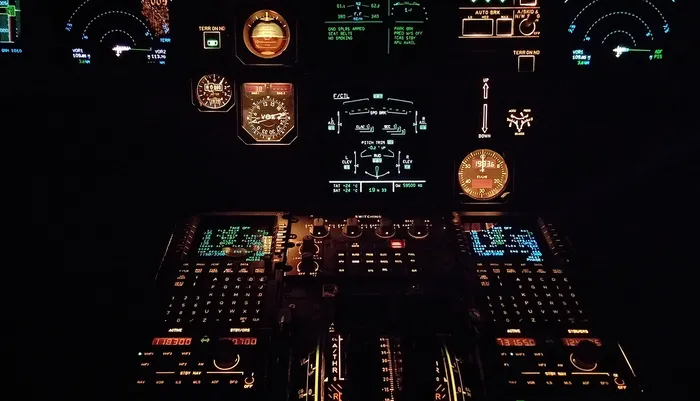 Airplane cockpit with all the meters and gauges lit up.
