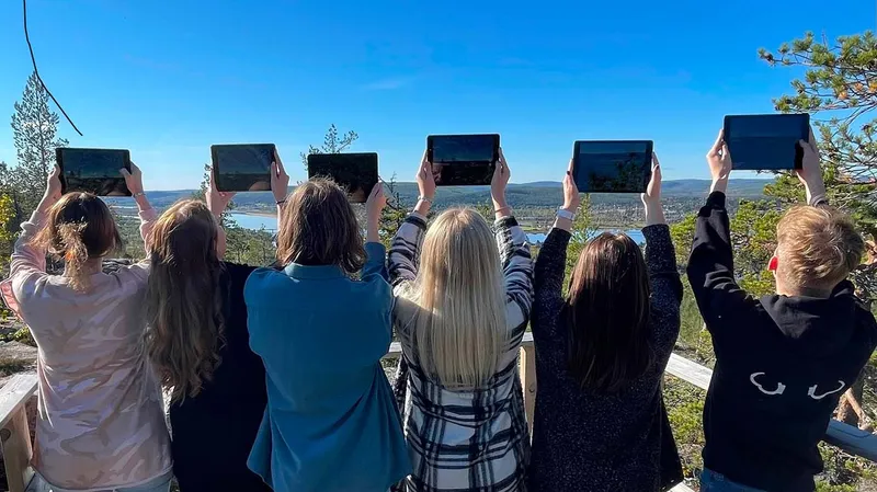Group of students holding their iPads up, learning about nature