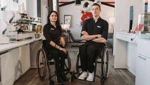 Two people in wheelchairs in a company kitchen
