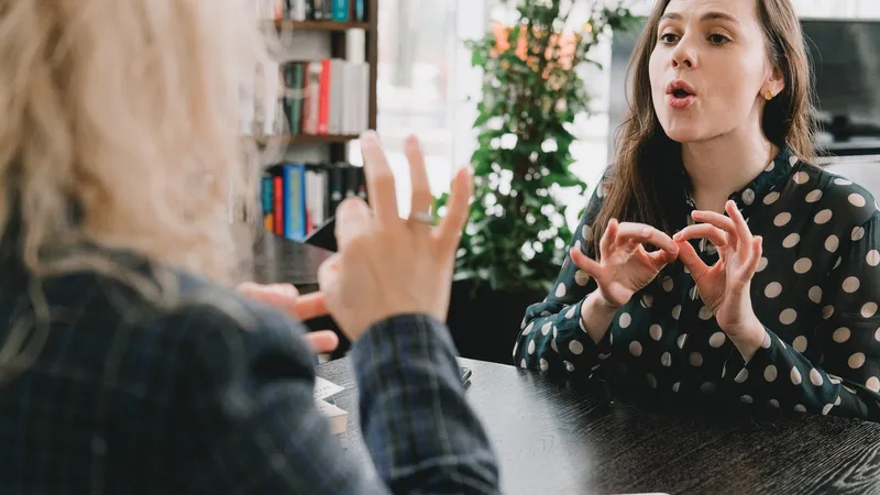Women in an office communicate with sign language.