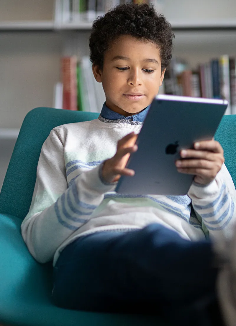 Child in school, learning on an iPad protected by Jamf Safe Internet.