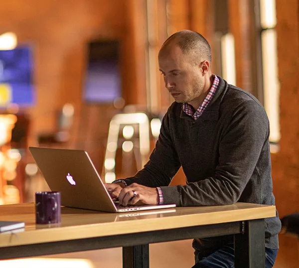 Employee works on a MacBook secured by Jamf solutions.